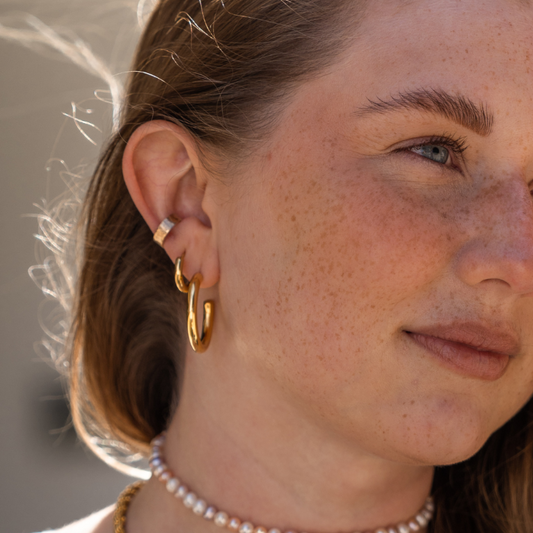 Perlenchoker, Earcuff und Goldschmuck von LIJA an einem braunhaarigen Model