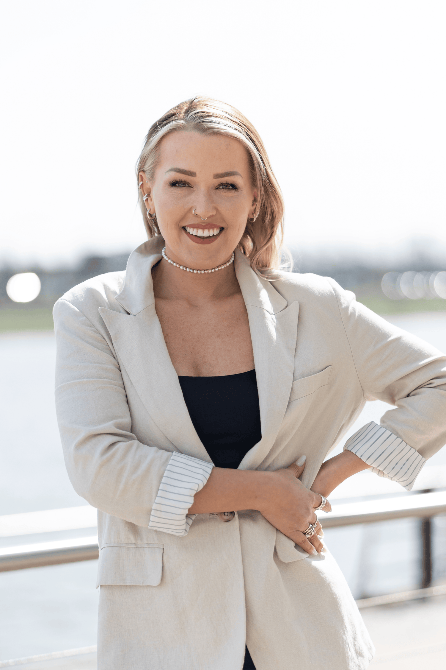 Foto der Gründerin von LIJA-Jewelry in beigem Blazer, selbstbewusst und stark, trägt ihren eigenen handgefertigten Schmuck - made in germany.